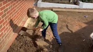 A child uses a children's spade from Kent and Stowe.