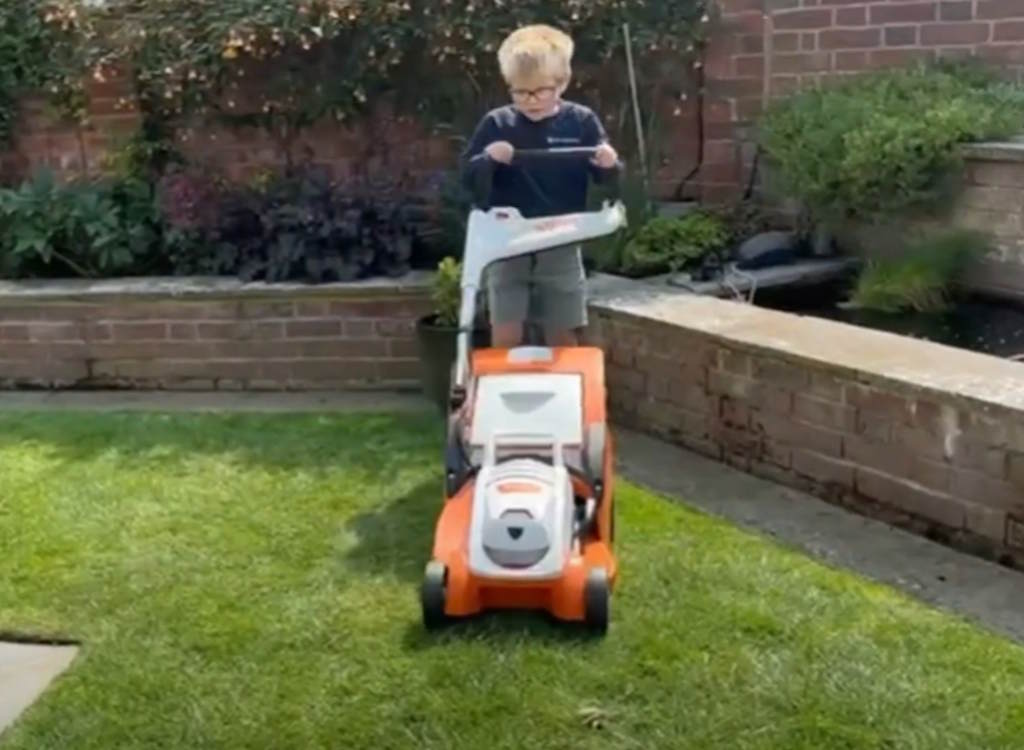 A youngster uses a lawn mower from Stihl,